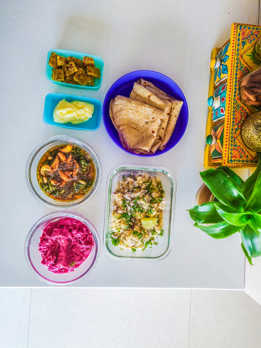 Homemade Indian dishes arranged on a white kitchen counter.