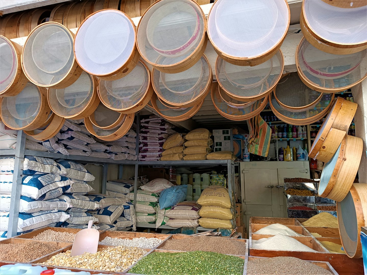 Bulk spices and grains displayed in a traditional market shop.