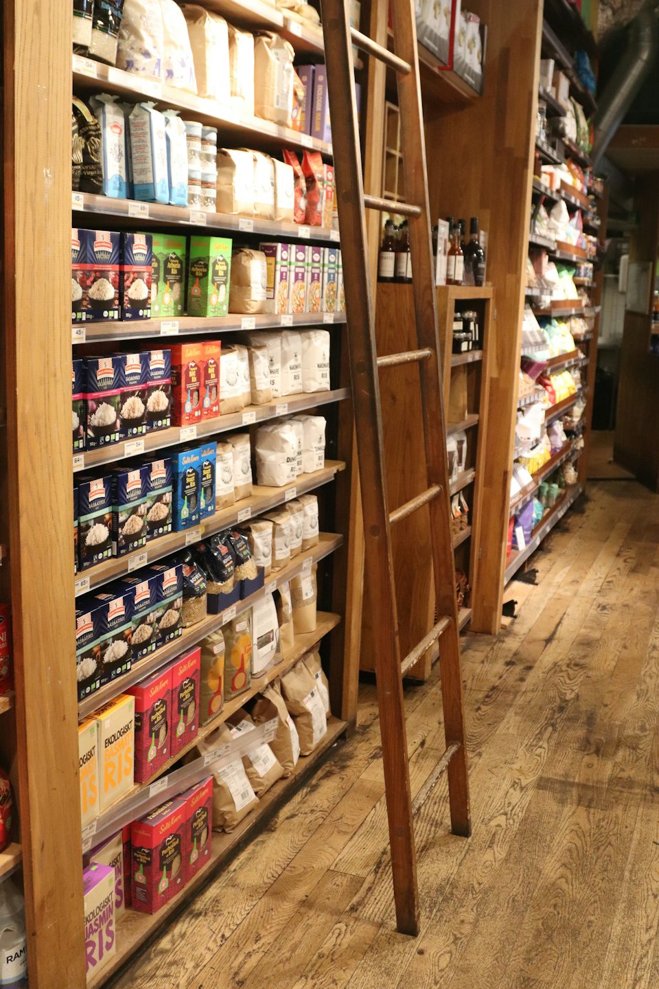 Wooden grocery store shelves filled with various packaged food products.