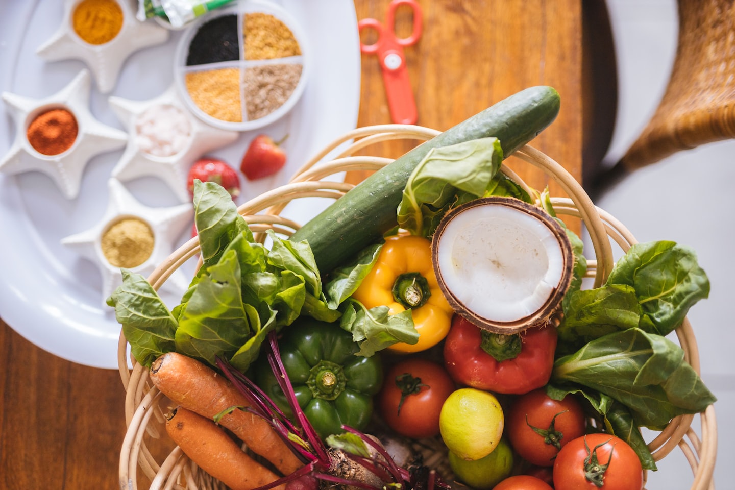 Fresh produce in a basket with spices on a tray.