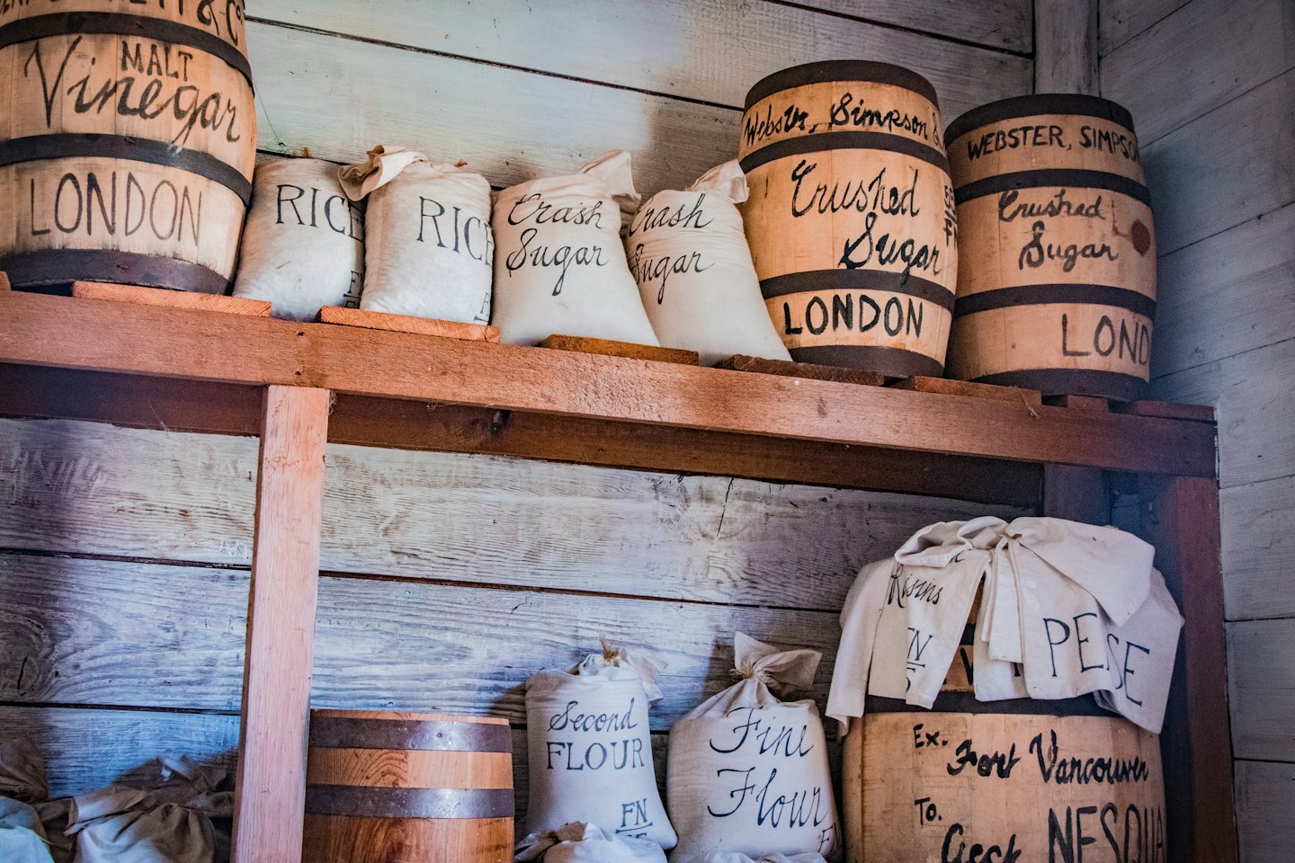 Wooden shelves in a general store stocked with vintage provisions.